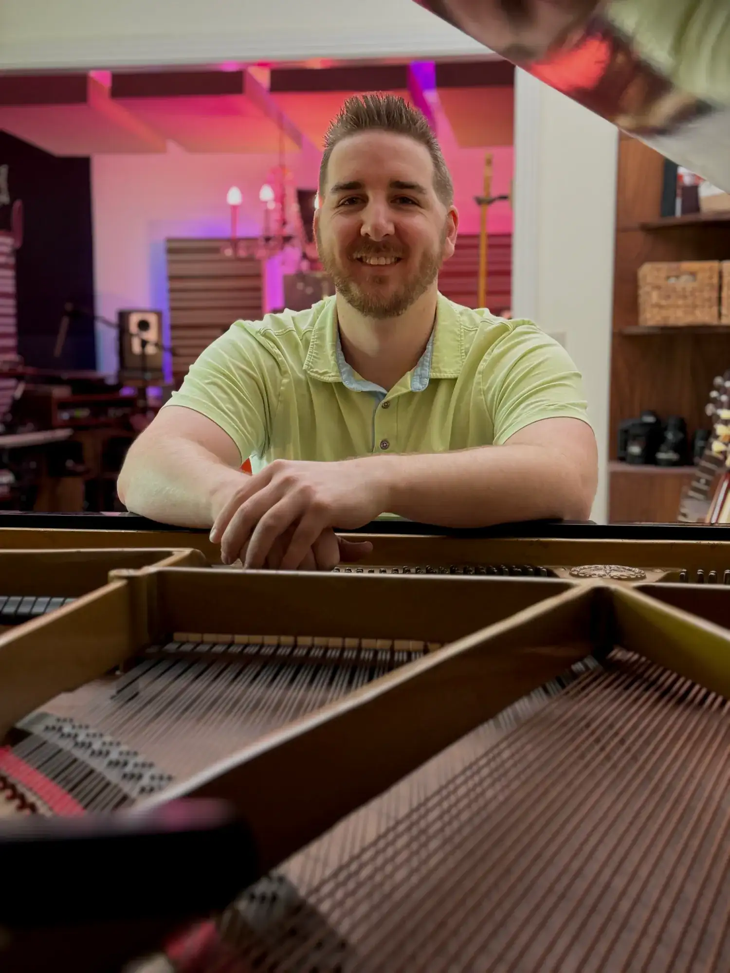 Pierce O’Brien seated behind the strings of a grand piano